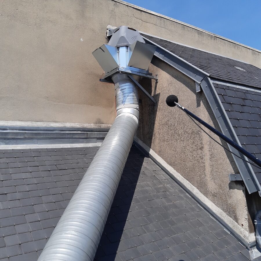 Système d'évacuation acoustique installé sur un toit, avec conduite métallique et sortie visible.